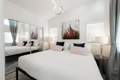 a white bedroom with two beds and a couch at Beautiful Courtyard Cottage Amethyst in Reno