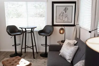 a living room with a couch and a table and stools at Cottage on Historic Grounds Citrine in Reno