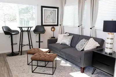 a living room with a gray couch and a stool at Cottage on Historic Grounds Citrine in Reno