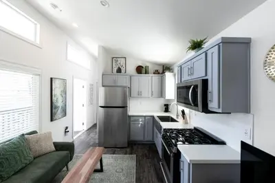 a kitchen with a stove top oven next to a couch at Cottage on Historic Grounds Jade in Reno