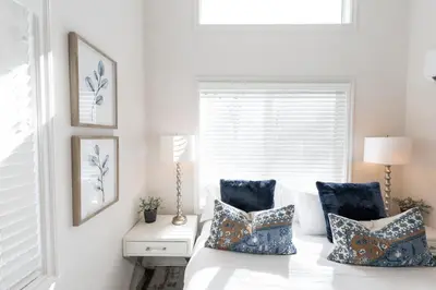 a bedroom with a bed with pillows and a window at Beautiful Cottage on Historic Grounds in Reno
