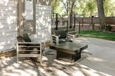 two chairs and a table next to a house at Beautiful Cottage on Historic Grounds in Reno