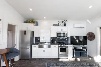 a kitchen with white cabinets and stainless steel appliances at Beautiful Cottage on Historic Grounds in Reno