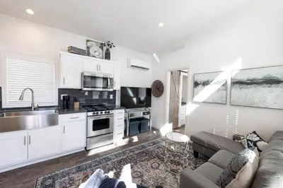 a living room with a couch and a kitchen at Beautiful Cottage on Historic Grounds in Reno