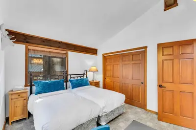 a bedroom with a bed and a wooden door at Northstar Retreat with Hot Tub & FREE Shuttle Access in Truckee