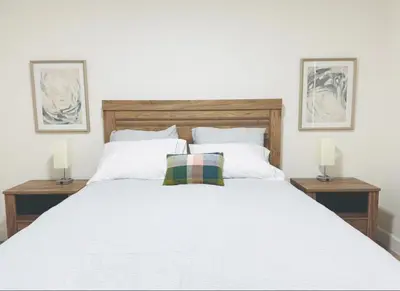 a bedroom with a large white bed with two lamps at Charming Retreat in CA Valley in Fresno