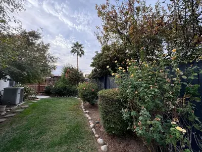 a garden with a fence and some bushes and trees at Charming Retreat in CA Valley in Fresno
