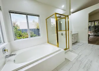 a white bathroom with a tub and a window at Charming Retreat in CA Valley in Fresno