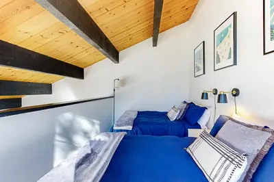 a bedroom with two beds and a wooden ceiling at Inn at South Lake Tahoe in Kings Beach