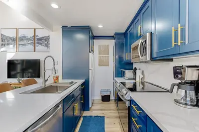 a blue kitchen with blue cabinets and a sink at Inn at South Lake Tahoe in Kings Beach