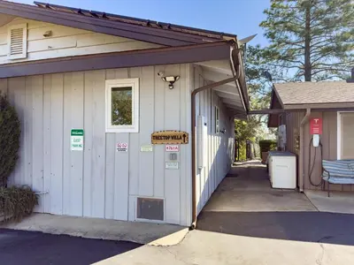 a small white building with a sign on it at Yosemite Mountain Top - Treetop Villa in Mariposa