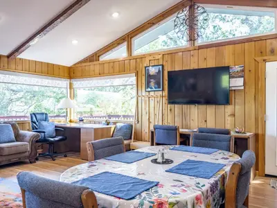 a dining room with a table and chairs and a television at Yosemite Mountain Top - Treetop Villa in Mariposa
