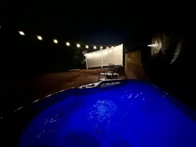 a blue hot tub in a dark yard at night at Puffy Panda RV-Hot Tub-Sleeps 2 in Ahwahnee