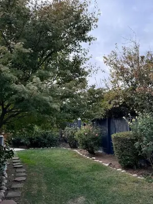 a yard with a fence and trees and grass at Charming retreat in CA Valley in Fresno