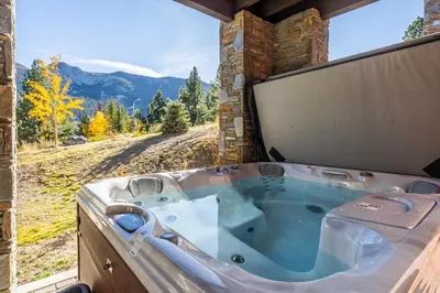 a jacuzzi tub with a view of the mountains at Creekhouse 1374 in Mammoth Lakes
