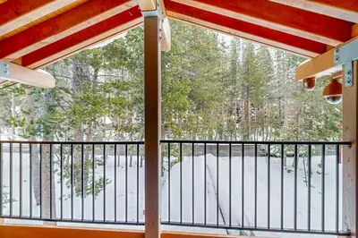 a balcony with a view of a snow covered yard at The Calder Cabin in Soda Springs