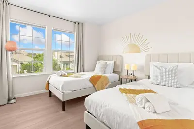 two beds in a white room with a window at Remodeled 3B2B Bright House with a King Suite in Sacramento
