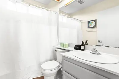 a white bathroom with a toilet and a sink at Remodeled 3B2B Bright House with a King Suite in Sacramento