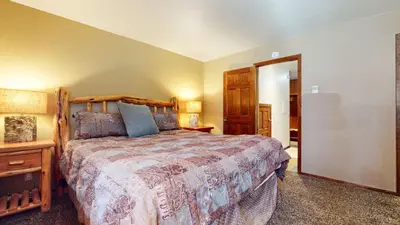 a bedroom with a large bed with a wooden frame at Winterset #33 condo in Mammoth Lakes