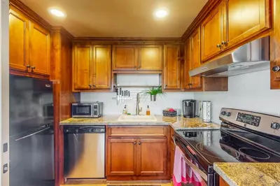 a kitchen with wooden cabinets and a sink at Morgan Hill Couples Gem Villa in the Vineyards in Morgan Hill