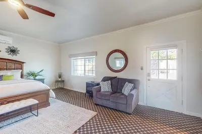 a bedroom with a bed and a chair and a mirror at Morgan Hill Couples Gem Villa in the Vineyards in Morgan Hill