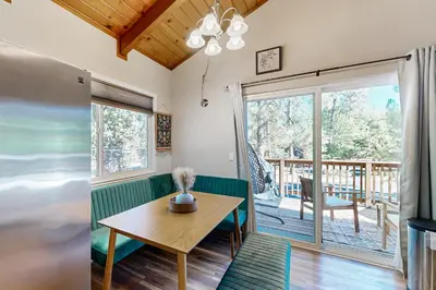 a living room with a table and a balcony at Green Abode in Groveland