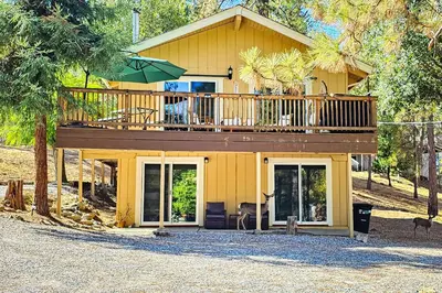 a yellow house with a deck on top of it at Green Abode in Groveland
