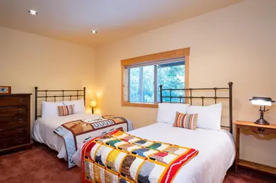 a bedroom with two beds and a window at Hillside Mountain Creek Haven home in Truckee