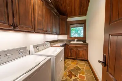 a kitchen with wooden cabinets and a washer and dryer at Serenity at Dollar Point - Luxurious 4BR w Private Backyard in Tahoe City