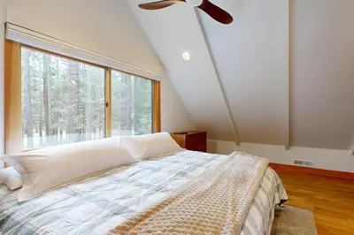 a bedroom with a bed and a large window at Tahoe West Shore Escape in Tahoe City
