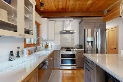 a large kitchen with white counter tops and wooden ceilings at Tahoe West Shore Escape in Tahoe City