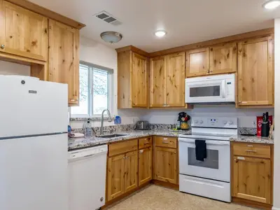 a kitchen with wooden cabinets and white appliances at Yosemite Mountaintop Retreat on 100 acres, 2 Homes, 2 hot tubs, pool in Mariposa