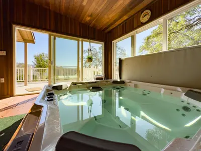 a jacuzzi tub in a room with windows at Yosemite Mountaintop Retreat on 100 acres, 2 Homes, 2 hot tubs, pool in Mariposa