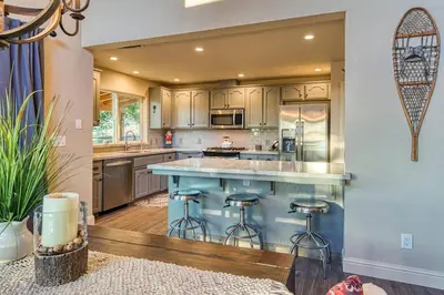 a kitchen with a large island with bar stools at Sunset Retreat AC, Big Views & Dream Deck in Shaver Lake