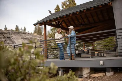 two women standing on a porch of a building at Sunset Retreat AC, Big Views & Dream Deck in Shaver Lake