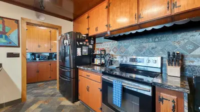a kitchen with a stove and a refrigerator at Lakefront Haven by AvantStay Minutes to Ski Resorts Private Dock in Homewood
