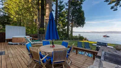 a patio with a table with chairs and an umbrella at Lakefront Haven by AvantStay Minutes to Ski Resorts Private Dock in Homewood