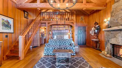 a living room with a bed and a fireplace at Homewood Lakefront by AvantStay Private Beach Lake Access Views in Homewood