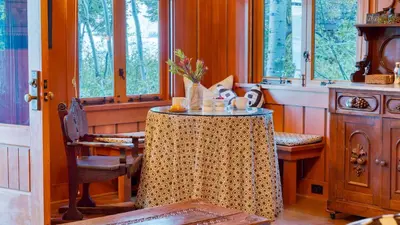 a dining room with a table and some windows at Homewood Lakefront by AvantStay Private Beach Lake Access Views in Homewood