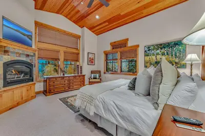a bedroom with a large bed and a fireplace at Northstar Ski-In Ski-Out with Valley Views in Ponderosa Fairway Estates