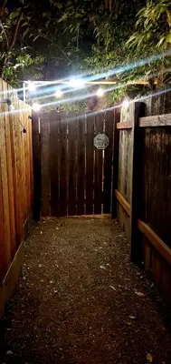 a wooden fence with a gate with a light on it at Secret Oasis in Sacramento! in Sacramento
