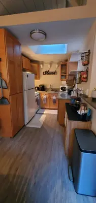 a kitchen with wooden cabinets and a white refrigerator at Secret Oasis in Sacramento! in Sacramento