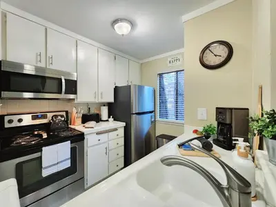 a kitchen with a stainless steel refrigerator and a clock on the wall at Tahoe Shoreline Retreat - Close to Ski Resorts & HOA Amenities in Tahoe Vista