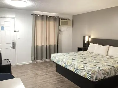 a hotel room with a bed and a sliding glass door at Motel 6 Selma, CA in Selma