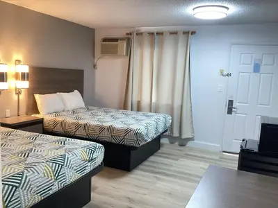a hotel room with two beds and a television at Motel 6 Selma, CA in Selma