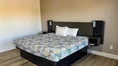a bed in a hotel room with a large bed at Motel 6 Selma, CA in Selma