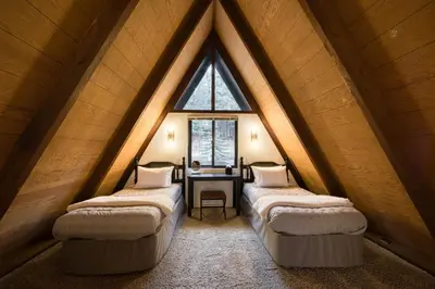 a attic room with three beds and a table at A-Frame of Mind in Tahoe Donner - Pet-Friendly 2 BR 1 BA with Pool Table in Truckee