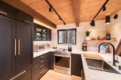 a kitchen with black cabinets and white counter tops at A-Frame of Mind in Tahoe Donner - Pet-Friendly 2 BR 1 BA with Pool Table in Truckee