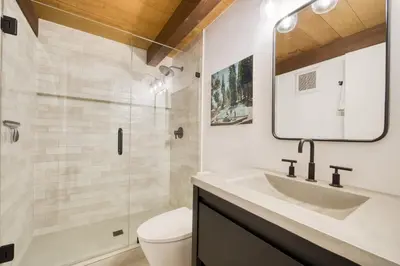 a bathroom with a sink and a toilet and a mirror at A-Frame of Mind in Tahoe Donner - Pet-Friendly 2 BR 1 BA with Pool Table in Truckee