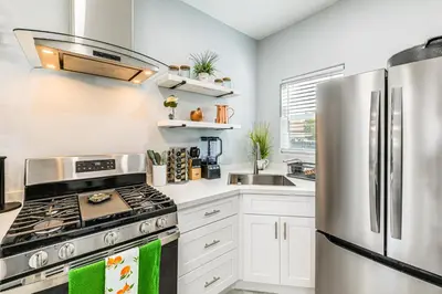 a kitchen with a stainless steel refrigerator and white cabinets at Small-Town Charm and Patio Dining Home in Madera! in Madera
